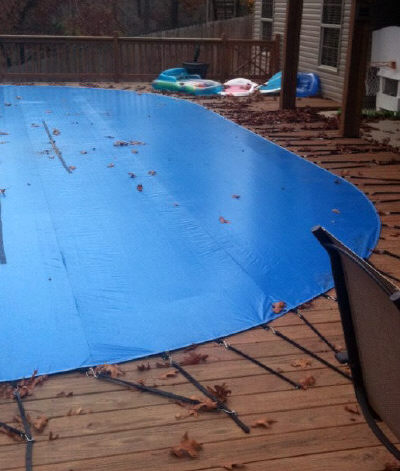 winter cover strapped to pool deck